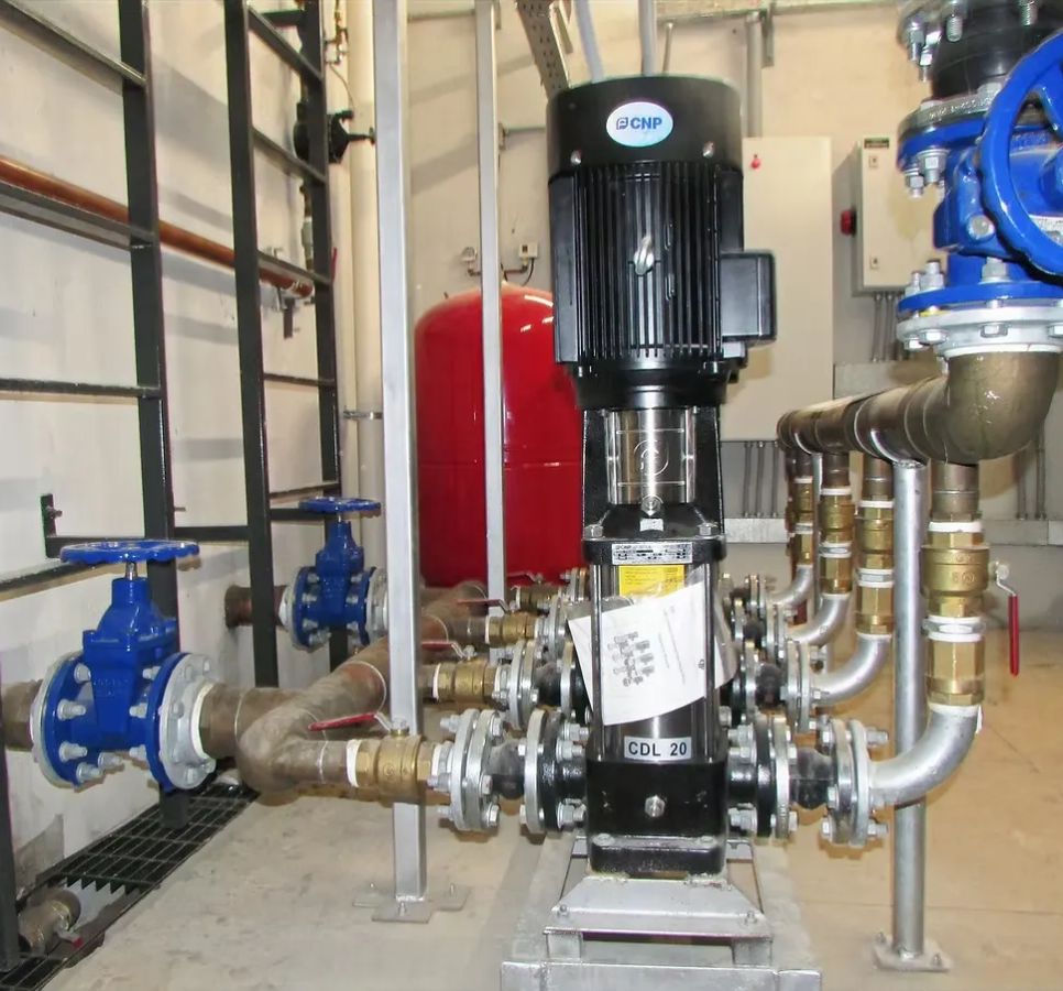 Sala de bombas con bomba vertical CNP, cañerías de cobre y válvulas azules
